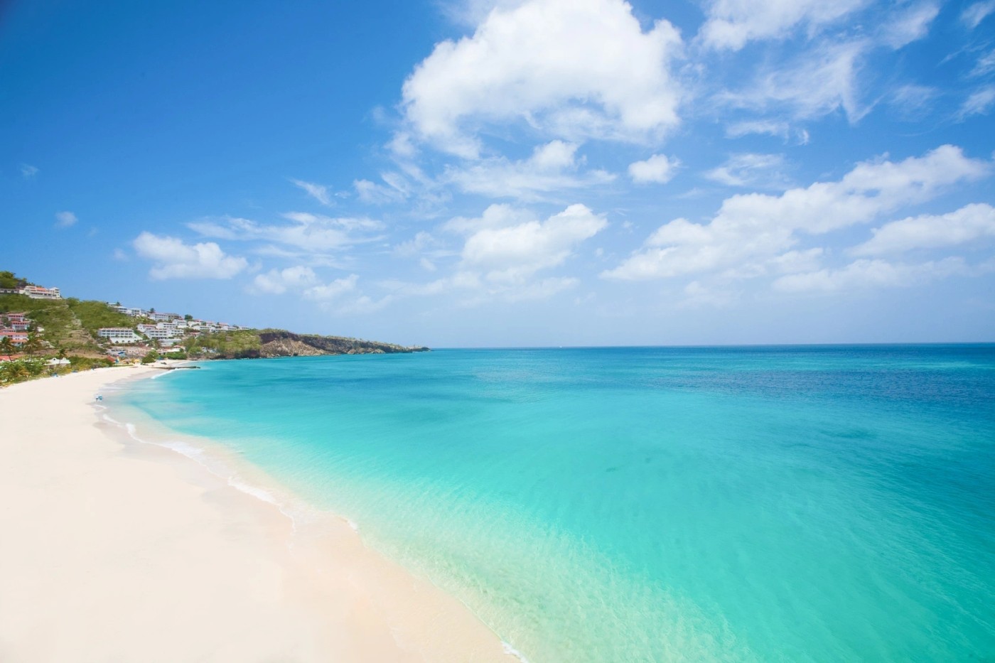 Soft sand and turquoise Caribbean water along a beach in Grenada
