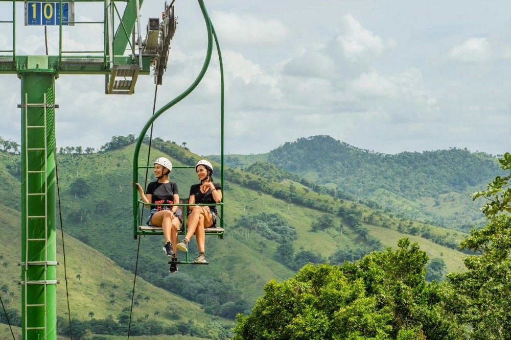 An elevated chairlift ride through a tropical adventure park