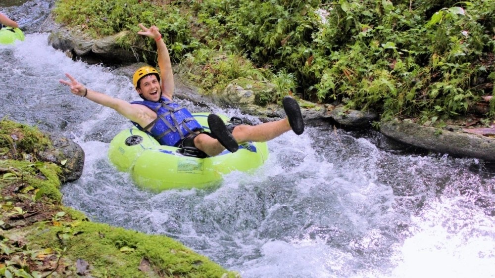 Guests river tubing through Jamaica’s tropical landscape