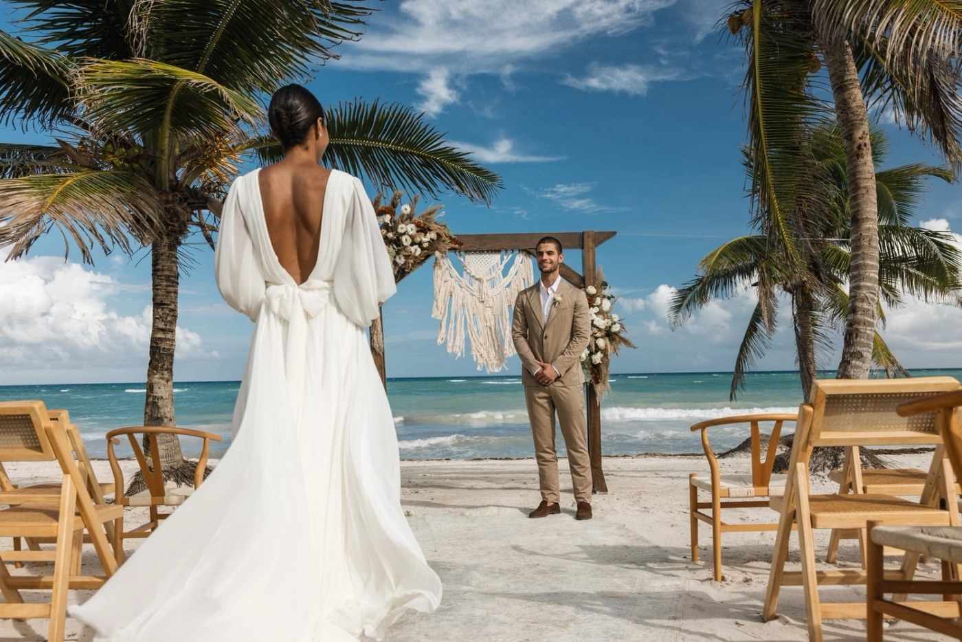 Bride walking toward her groom at a beach wedding